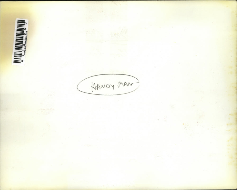 Press Photo Man Cutting Wood at his Campsite