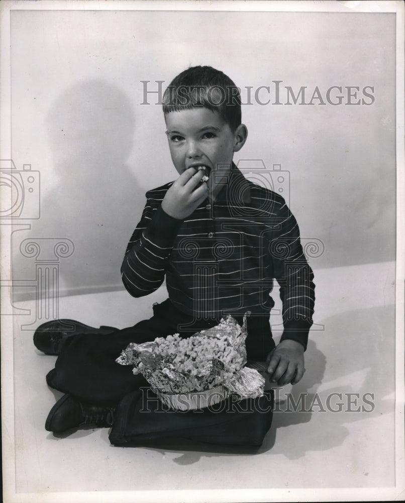 1954 Press Photo Lee Milligan relishes Christmas Popcorn