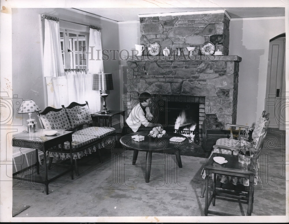 1955 Press Photo Mrs. Kelly tends a fire in the fireplace in cold days