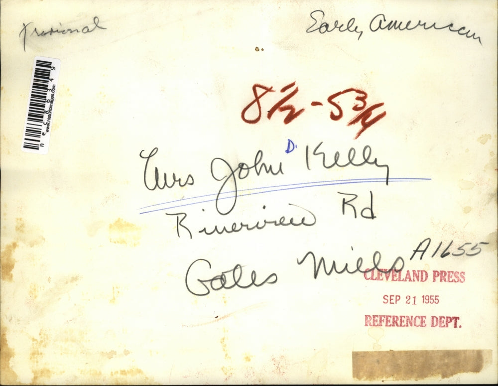 1955 Press Photo Mrs. Kelly tends a fire in the fireplace in cold days