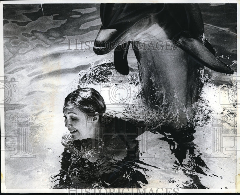 Load image into Gallery viewer, 1970 Press Photo Carolyn Walker and a dolphin in Porpoise Pool at Ocean World
