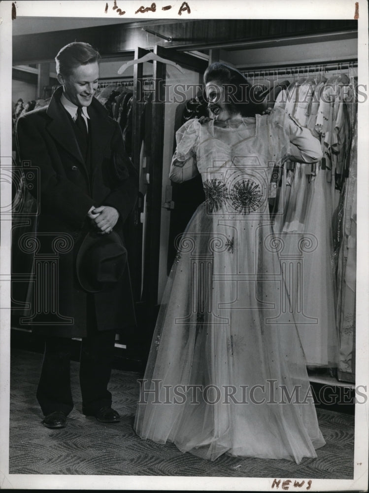 1943 Press Photo A woman & man as she tries gowns at a store