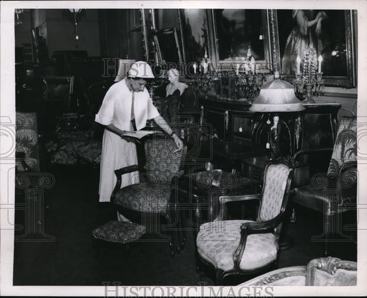 1953 Press Photo A woman bargain hunting furniture at a auction