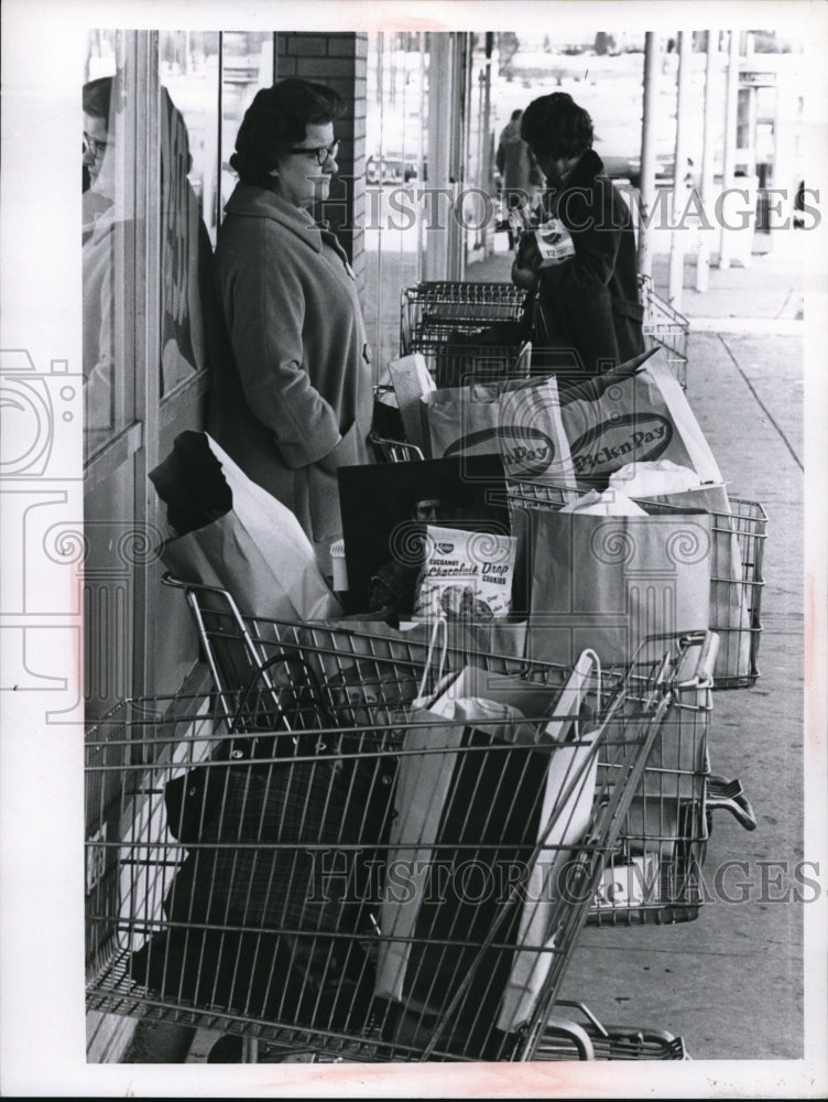Load image into Gallery viewer, 1963 Press Photo Women with carts wait for a bus in Cleveland
