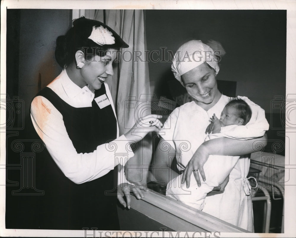 1957 Press Photo Mrs. Colombo plays with the baby carried by Nurse Perdo