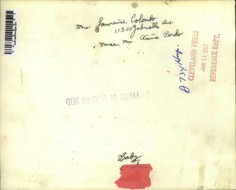 1957 Press Photo Mrs. Colombo plays with the baby carried by Nurse Perdo