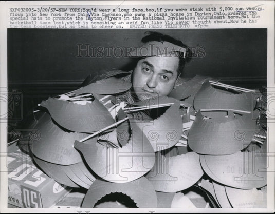 1957 Press Photo Vic Cassano stuck with Dayton Flyers visors after team loss