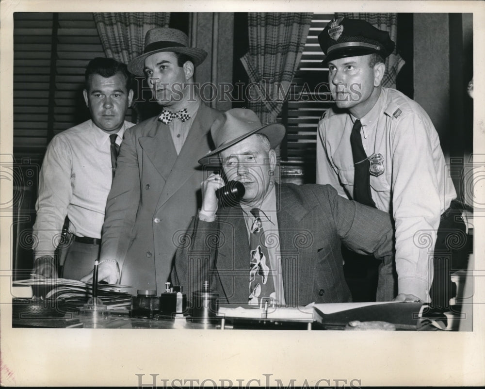 1947 Press Photo A group of men use atelephone at a police statio