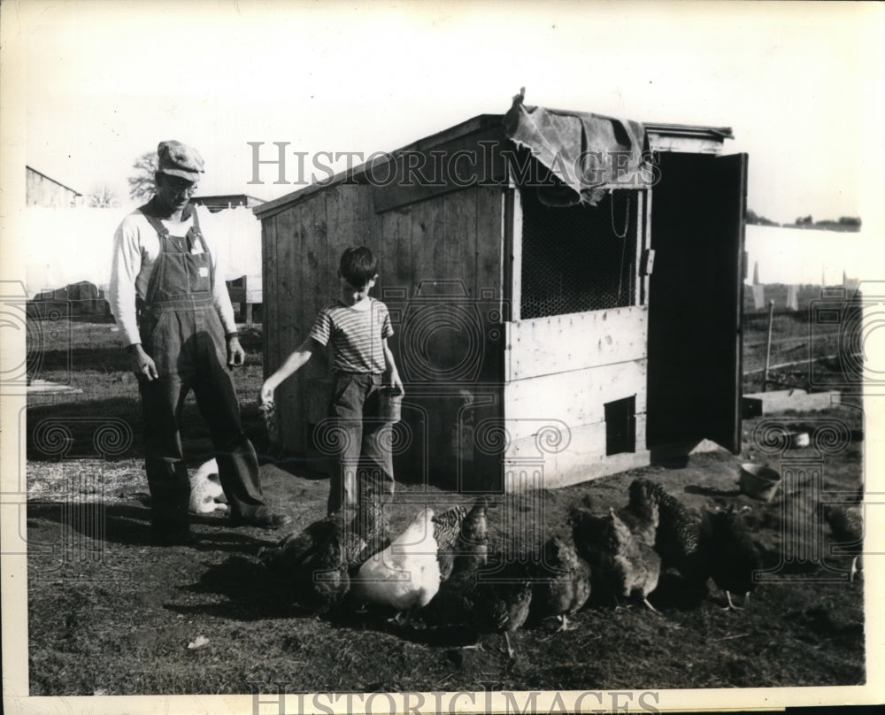 1945 Press Photo Mr Wilford Rose and Son Eugene feeding their Chickens