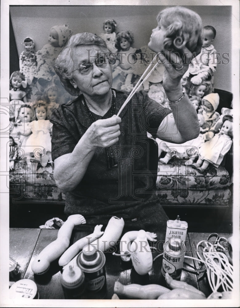 1961 Press Photo Mrs AA Embley Goodwill volunteer fixes dolls at store