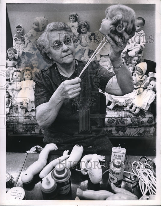 1961 Press Photo Mrs AA Embley Goodwill volunteer fixes dolls at store