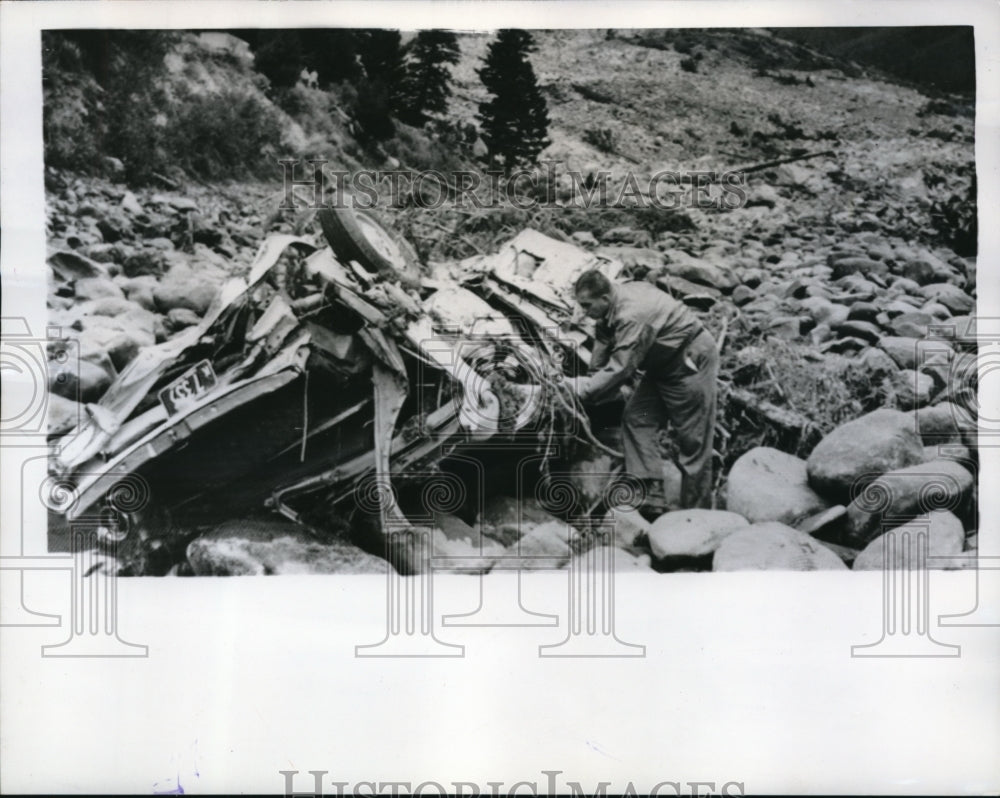 1959 Press Photo Robert Kennen UPI Reporter examine wreckage of a car.