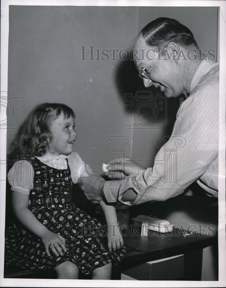 1955 Media Photo Kathy grins as Dr sterizes her arm said it tickles