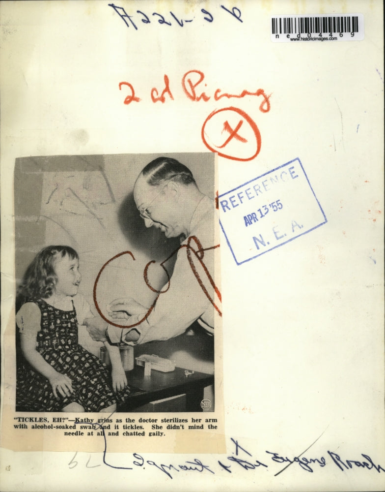 1955 Media Photo Kathy grins as Dr sterizes her arm said it tickles