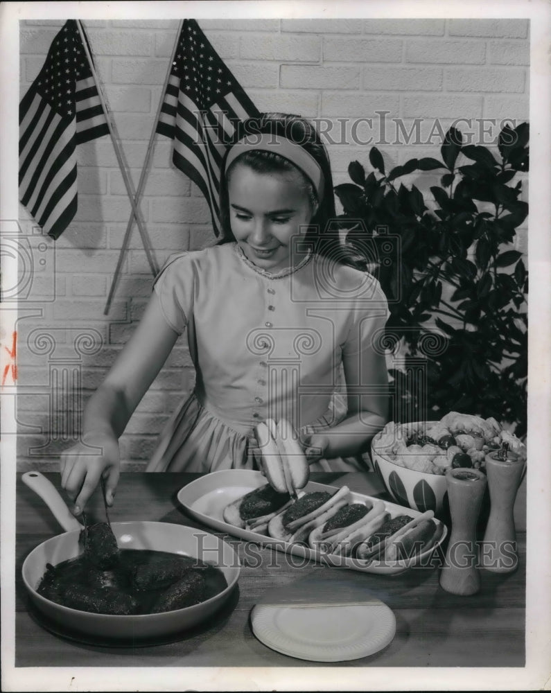 Load image into Gallery viewer, 1962 Press Photo Young Miss Maddox practices cooking fire-cracker burgers
