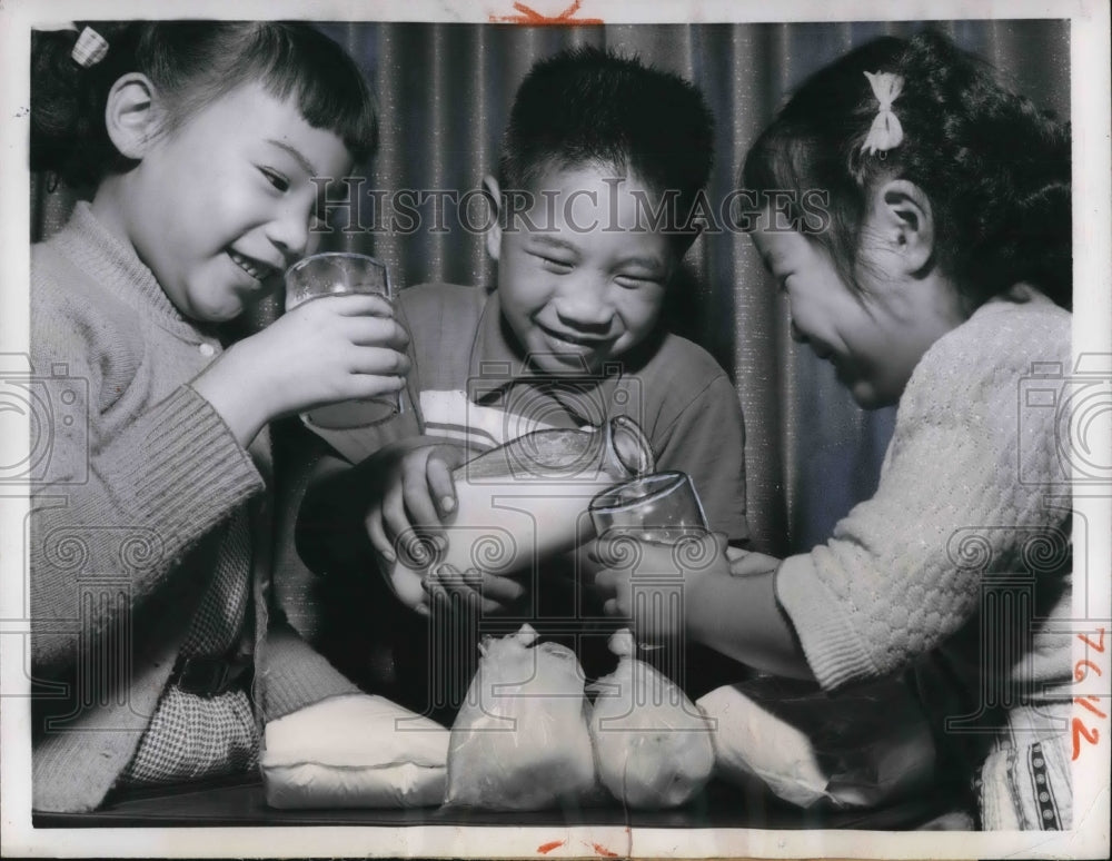 1957 Press Photo Bangkok Thailand 3 youngsters sample milk product from new
