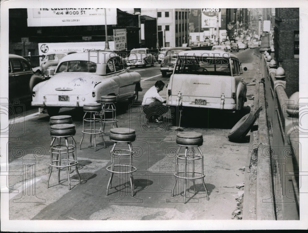 1952 Press Photo Pittsburgh Pa SA Nefopulas uses stools as he fixes flat tire