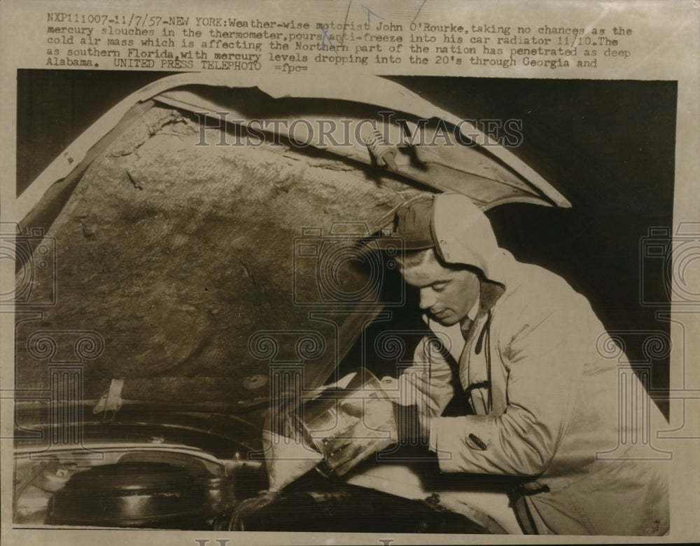 1957 Press Photo John O'Rourke pouring antifreeze into car, New York - ned07450