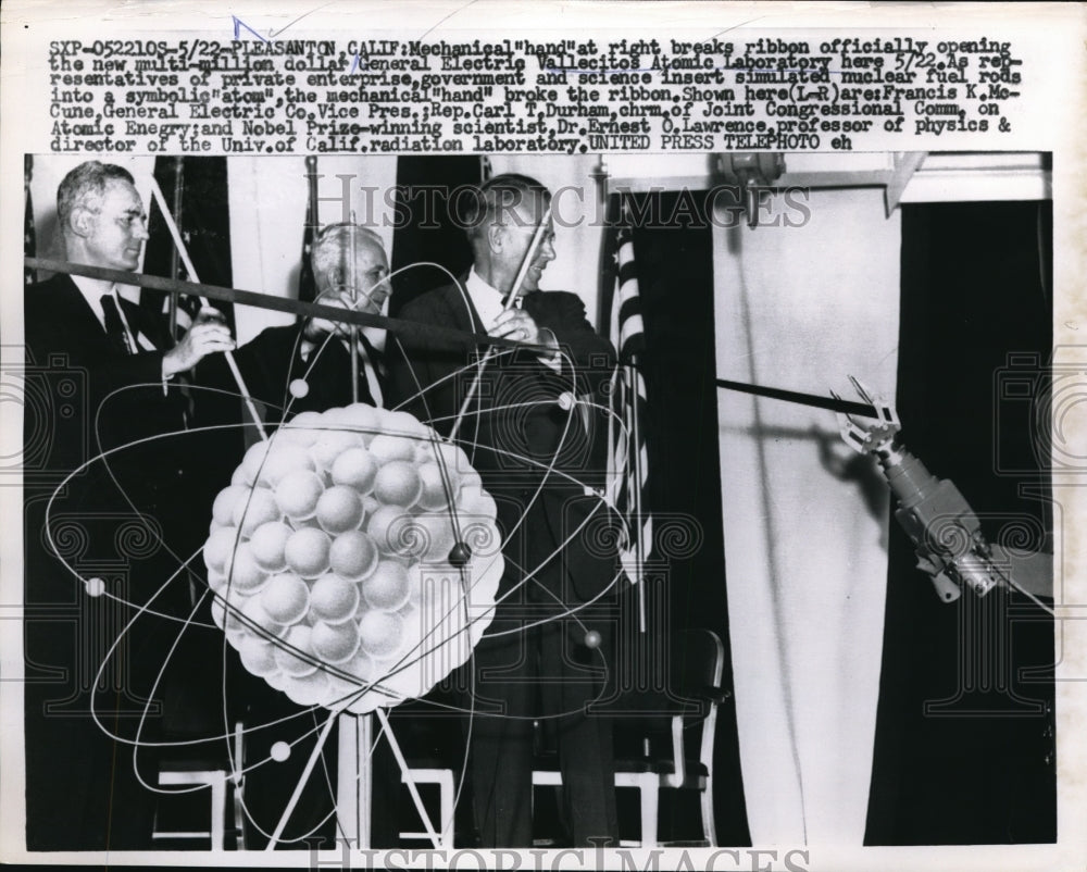 1957 Press Photo Mechanical hand breaks ribbon at the opening of new laboratory