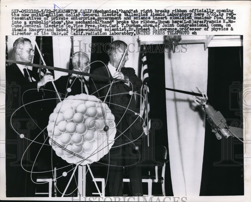 Load image into Gallery viewer, 1957 Press Photo Mechanical hand breaks ribbon at the opening of new laboratory
