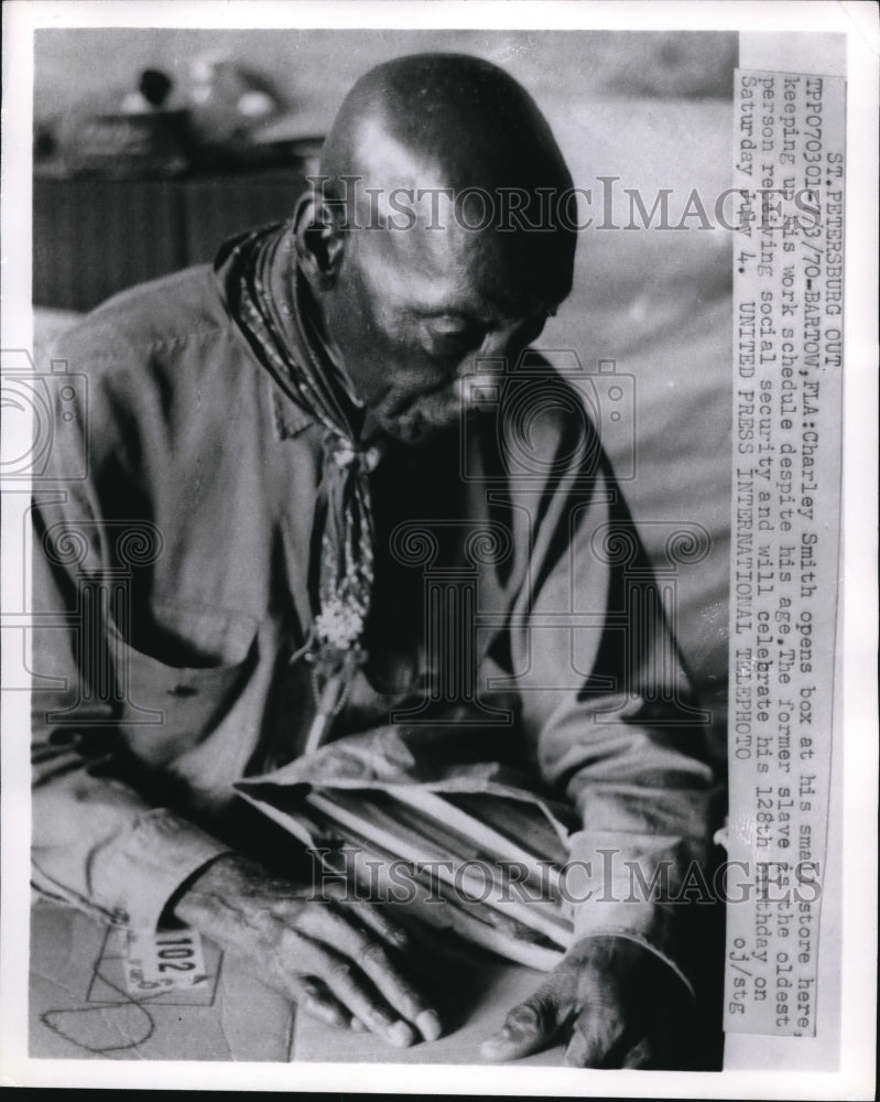 1970 Press Photo Charley Smith opening a box at his small store in Bartow FL
