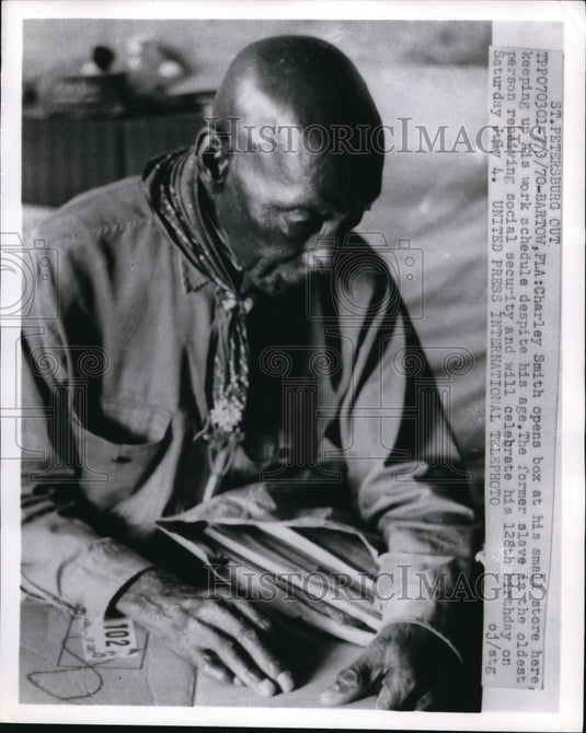 1970 Press Photo Charley Smith opening a box at his small store in Bartow FL