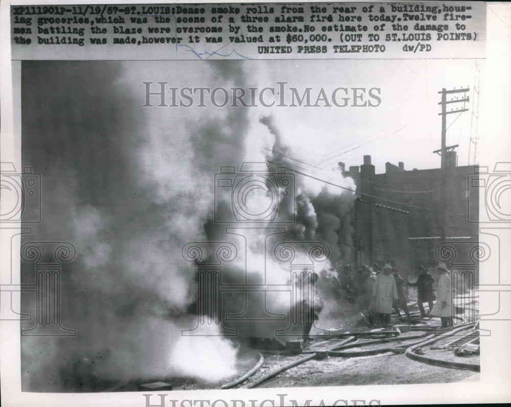 1957 Press Photo Smoke rolling from the rear of a building housing groceries