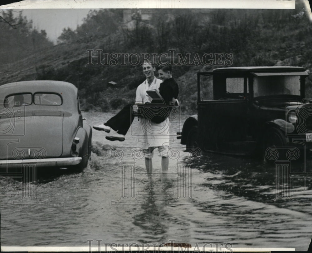 1938 Press Photo Student carries another to school in heavy rainstorm flooding