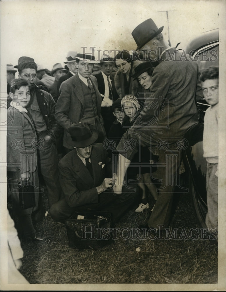 1935 Media Photo Dr JB Van Urk attends to injured foot of a man