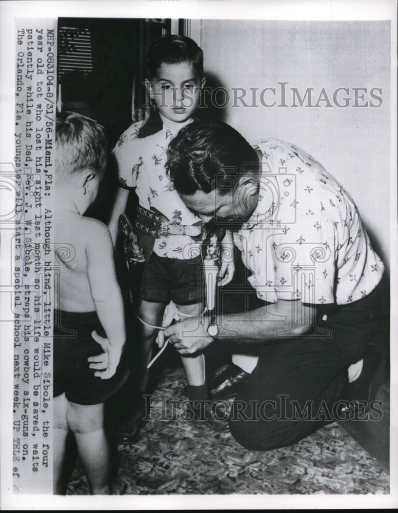 1956 Media Photo Mike Sibole waits patiently as his father ties his shoes