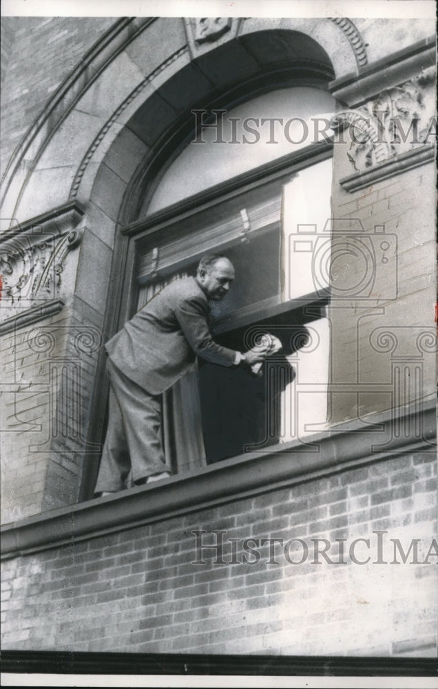 Load image into Gallery viewer, 1958 Press Photo Wilfred A. Desrosier Scrubs A Window Outside Of His Office
