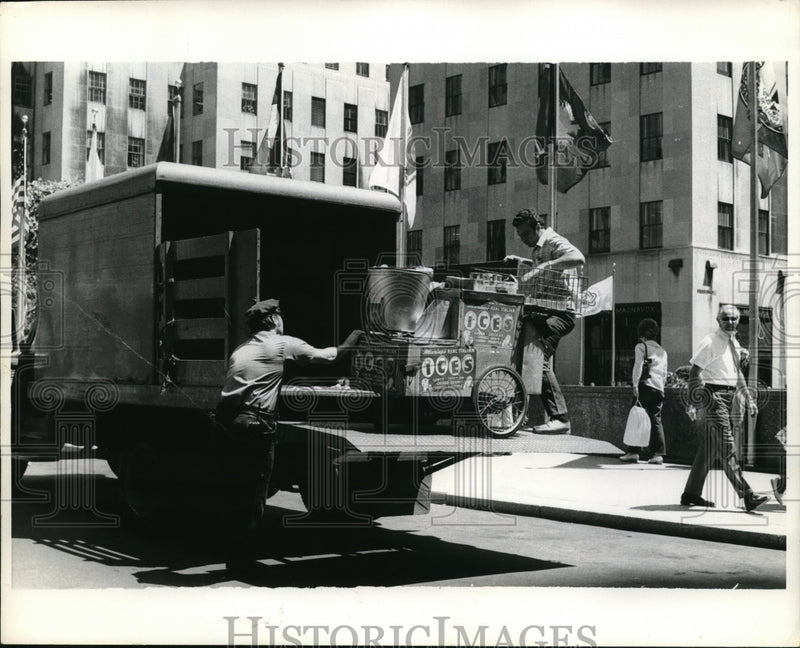 Load image into Gallery viewer, 1975 Press Photo Policeman And New Yorker Unload Refreshment Wagon - ned19808
