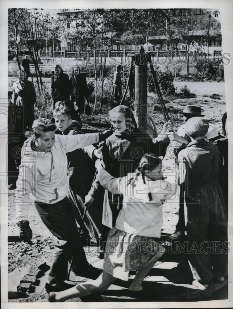 1959 Press Photo Kozmin brothers play merry-go-round with kids in Moscow