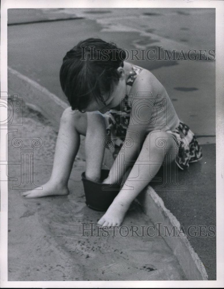 1960 Press Photo A Young Girl Playing With A Bucket In Water