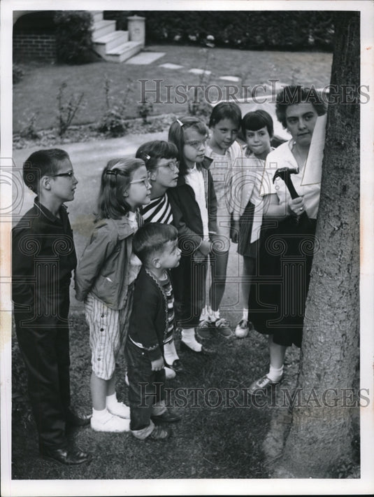 1961 Press Photo Mrs. Robert Sharp and a group of kids hanging up sign on tree.