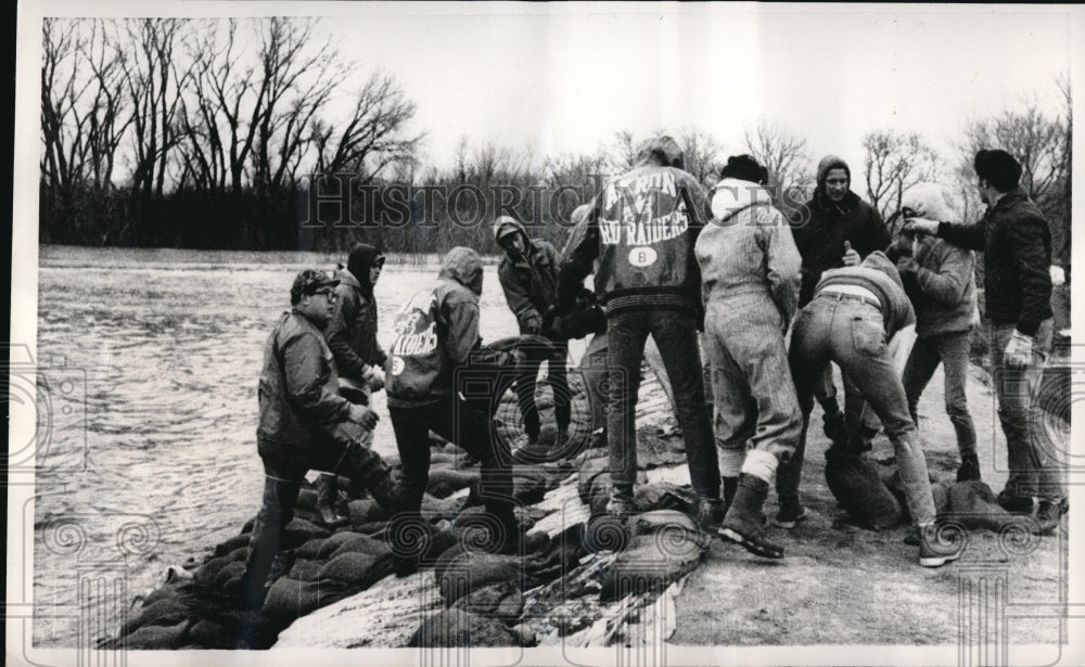 1969 Press Photo Volunteers piling sandbags to protect a city from a flood.