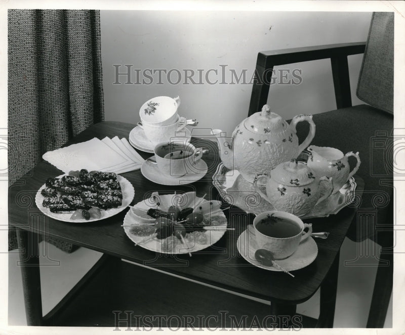 Load image into Gallery viewer, 1957 Press Photo A tea service and pastries for guests on atable display
