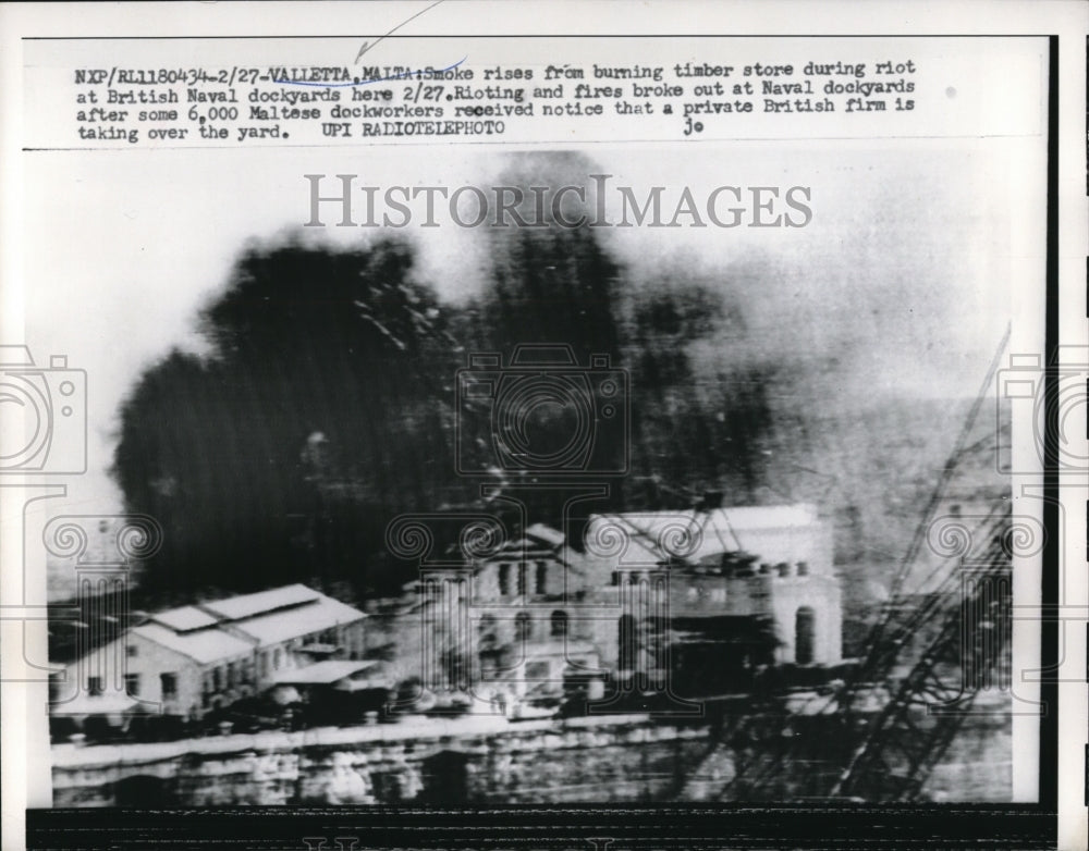 1959 Press Photo Smoke rises from burning timber store during riot at