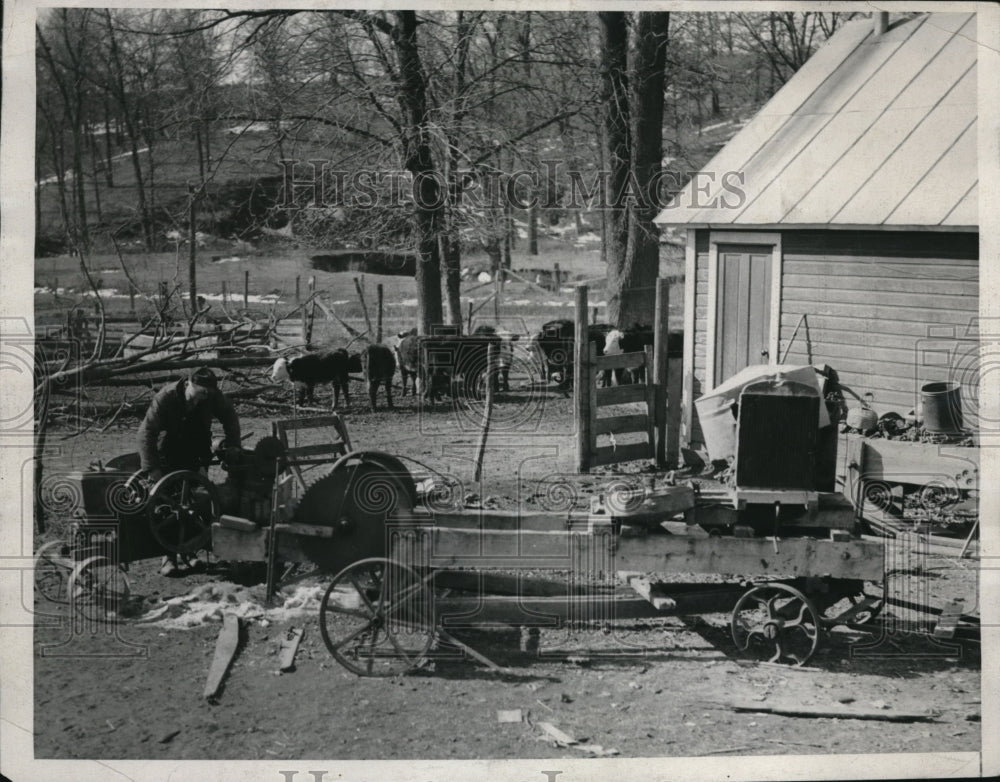 1933 Press Photo Farmer Albert Moore repairing some of his machinery on his