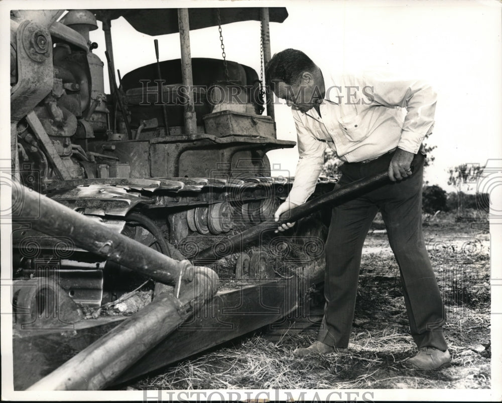 1957 Press Photo pitching in on land clearing project Norris wields king size