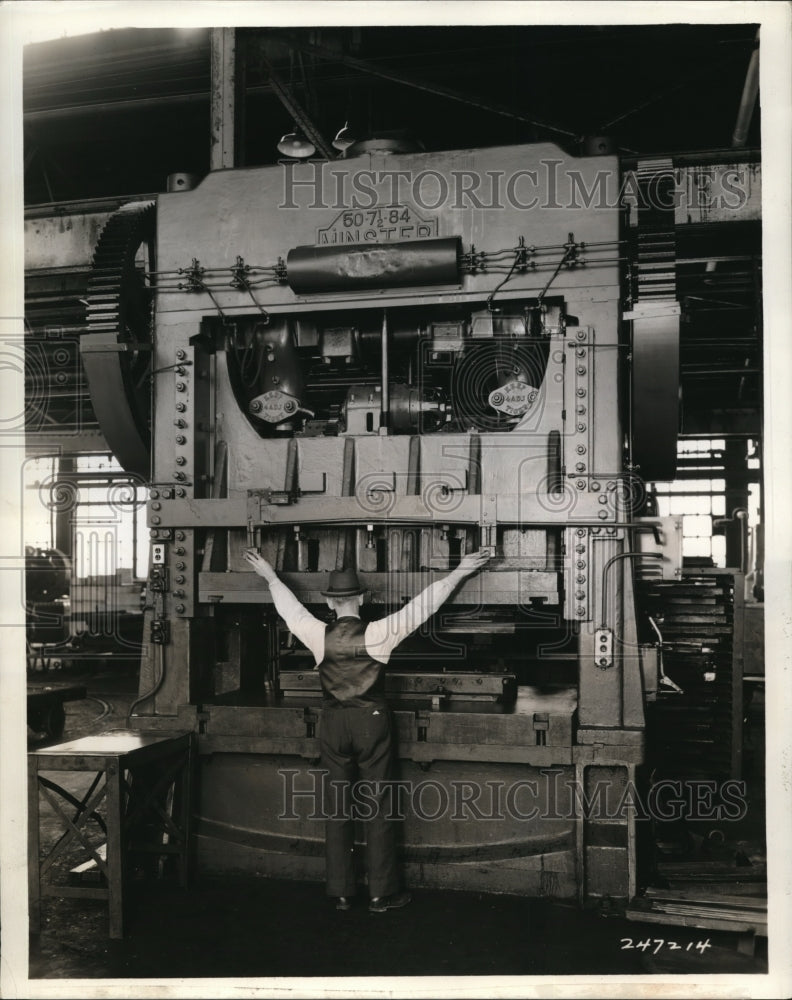 1939 Press Photo This worker must use both hands to operate the giant press