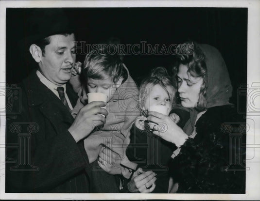 1945 Press Photo Dr. Dymas Eunes feeds son Dymas, Jr. while wife helps Carmen