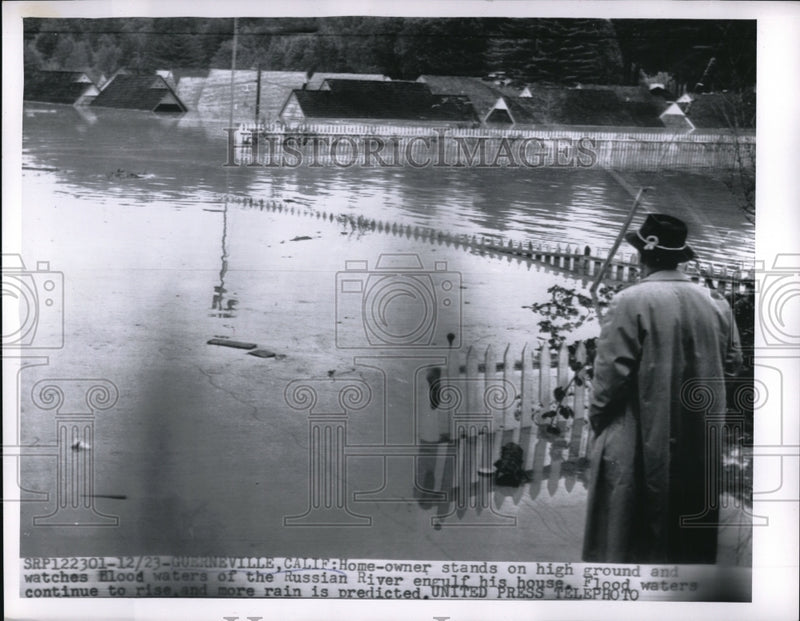 Load image into Gallery viewer, 1955 Press Photo Guerneville Calif a home owner stands on high ground and
