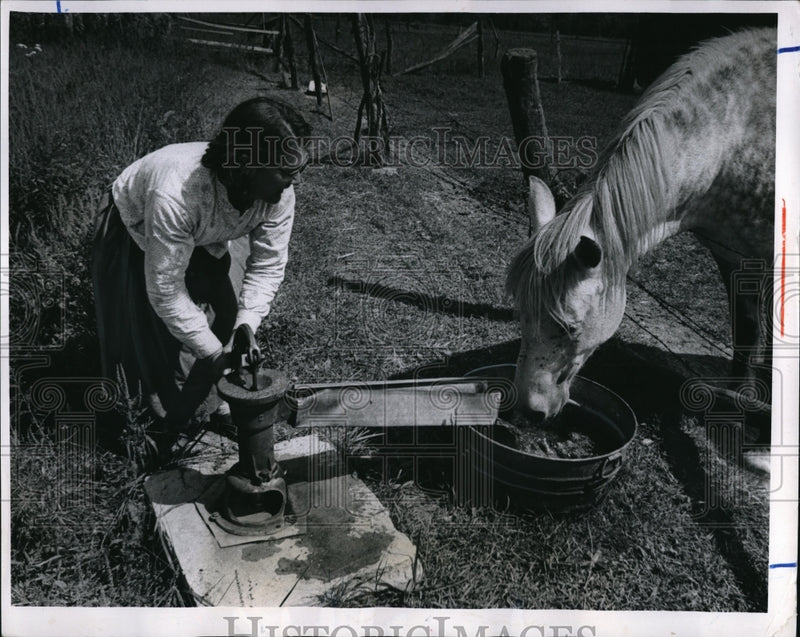 Load image into Gallery viewer, 1969 Press Photo Mamie Light pumps water for her horse
