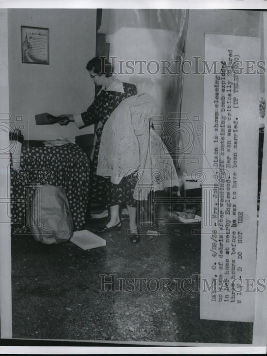 1956 Press Photo Mrs John G Dixon cleaning up debris of wedding gift bomb