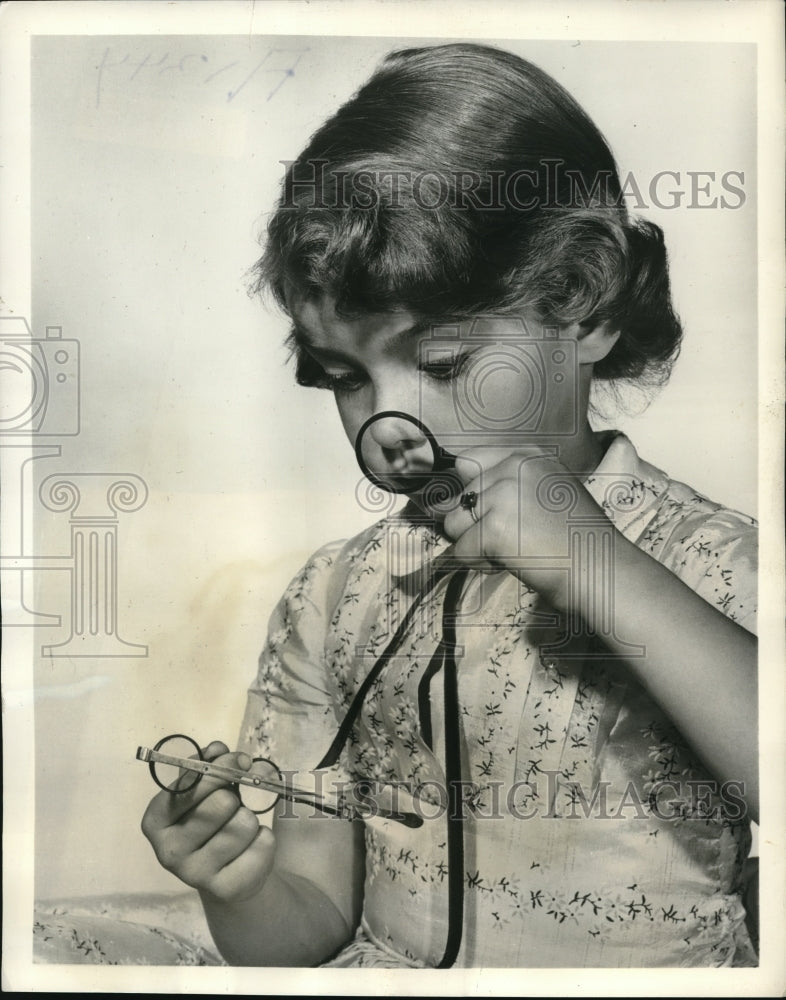 1957 Press Photo Leslie Frega at the House of Vision's looking at antique frames