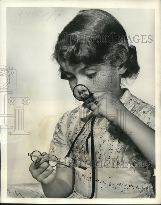 1957 Press Photo Leslie Frega at the House of Vision's looking at antique frames