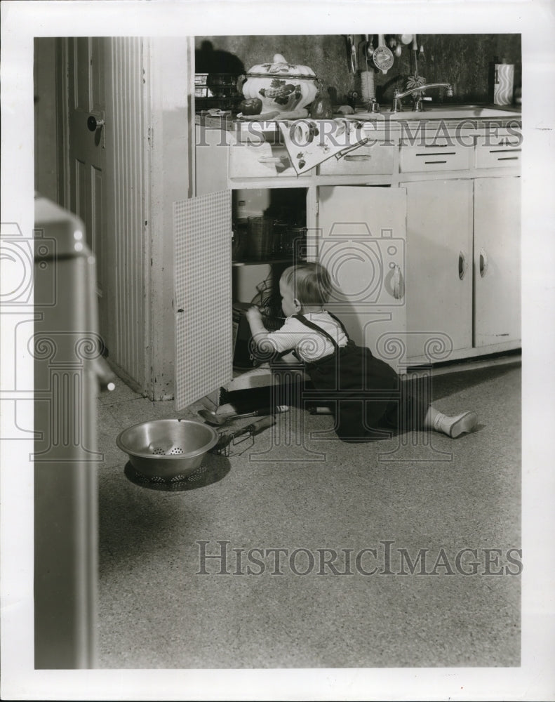 1956 Press Photo Man most in touch with kitchen floor is baby.  Resllient rubber- Historic Images