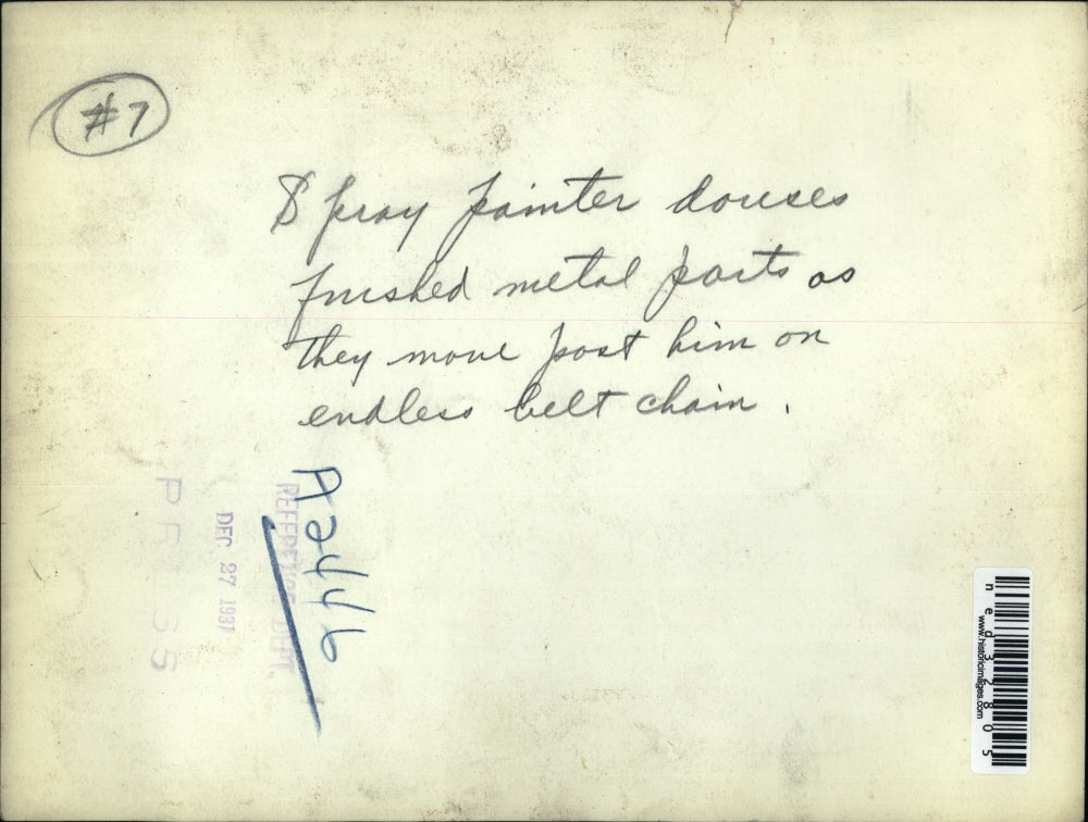 1931 Press Photo Spray painter paints metal parts on endless belt chain