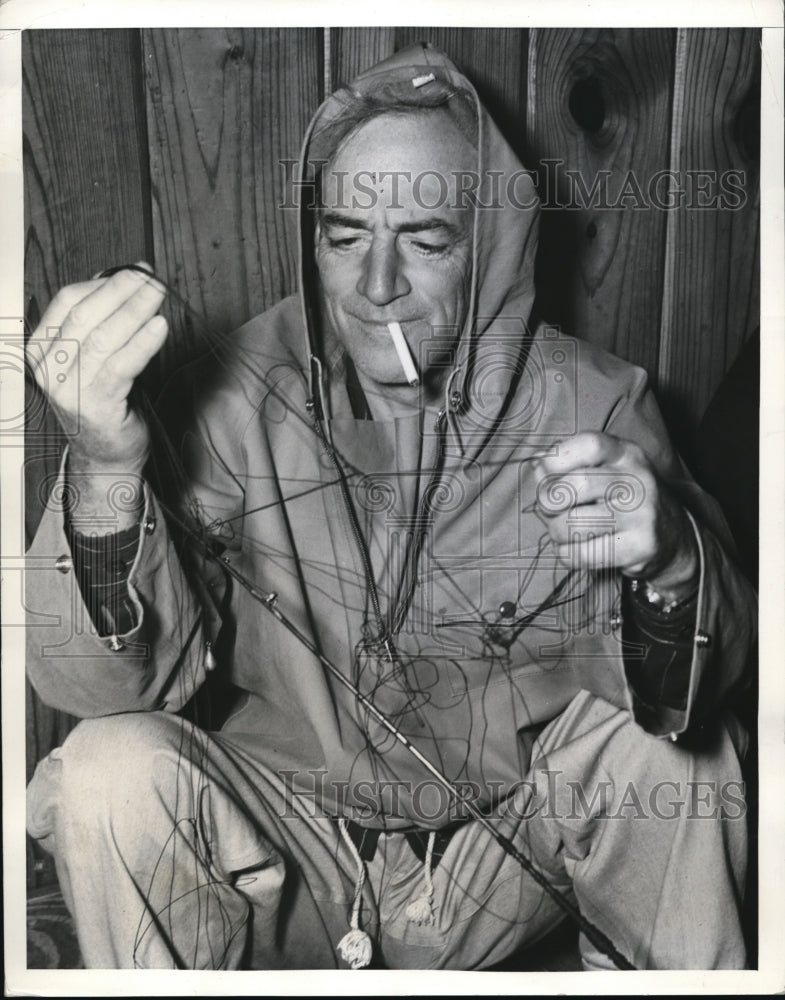 Load image into Gallery viewer, 1941 Press Photo Fisherman Walter Clark fixing his reel
